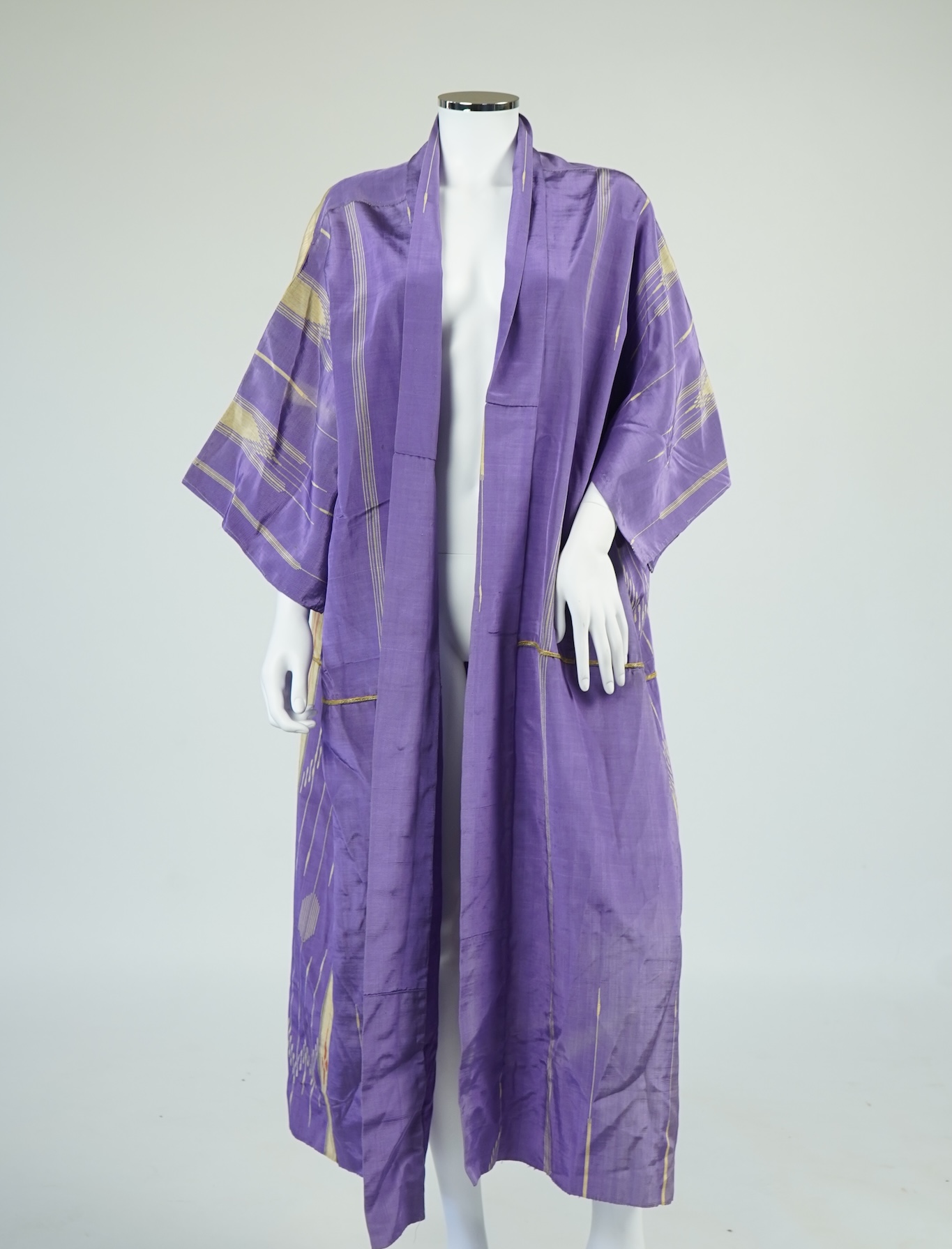 An early 20th century Syrian hand woven silk coat. Woven with stripes and geometric shapes in purple and yellow and red., 130 cm long. Condition - good, colours and fabric strong.